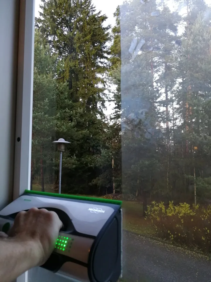 Vorwerk-ikkunanpesulaite ikkunalla: pesty puoli kirkas, pesem&auml;t&ouml;n puoli sumea