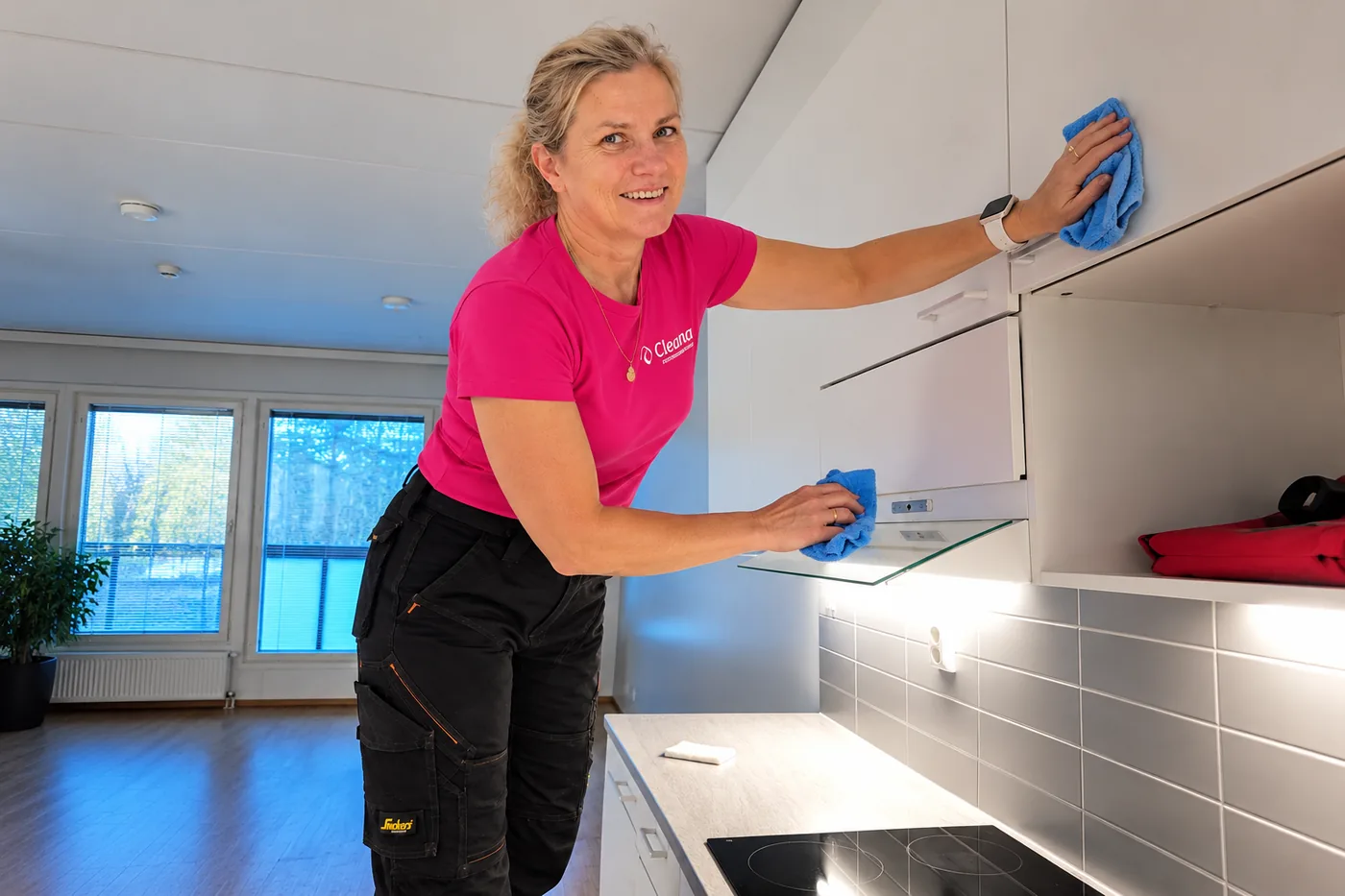 Cleanan ty&ouml;ntekij&auml; pyyhkii keitti&ouml;n kaapistojen pintoja