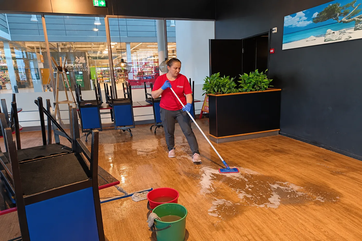 Cleanan ty&ouml;ntekij&auml; pesee ravintolan asiakastilan lattiaa