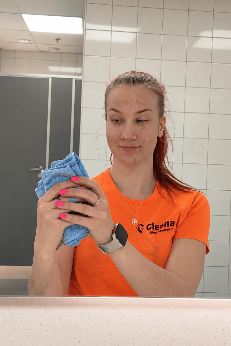 Cleanan ty&ouml;ntekij&auml; siivotussa wc-tilassa, mikrokuituliina k&auml;dess&auml;
